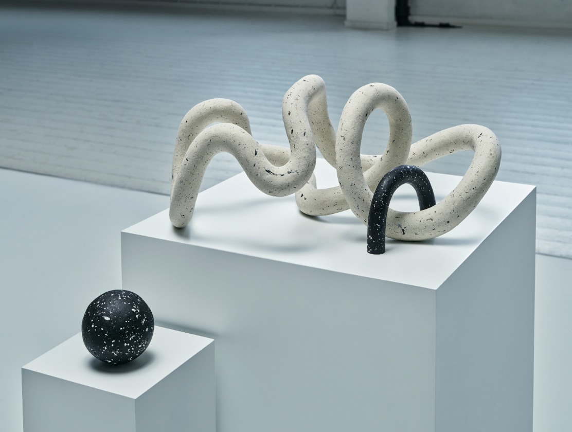 A biodegradable white and black sculpture looking like a three-dimensional doodle, made from recycled, natural materials.