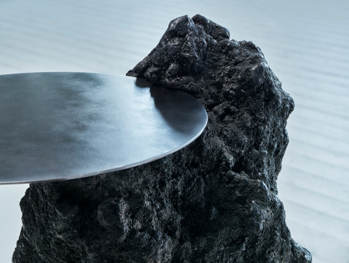 A table made from slag, a black lava-like steel industry waste material, and a round sheet of steel.
