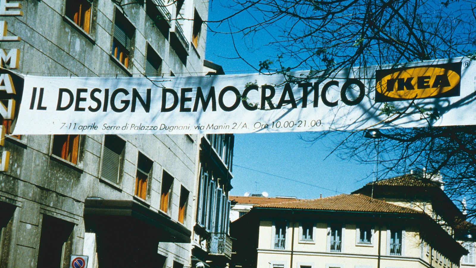 Big banner hanging above a city street, text in Italian says: Democratic Design, IKEA.