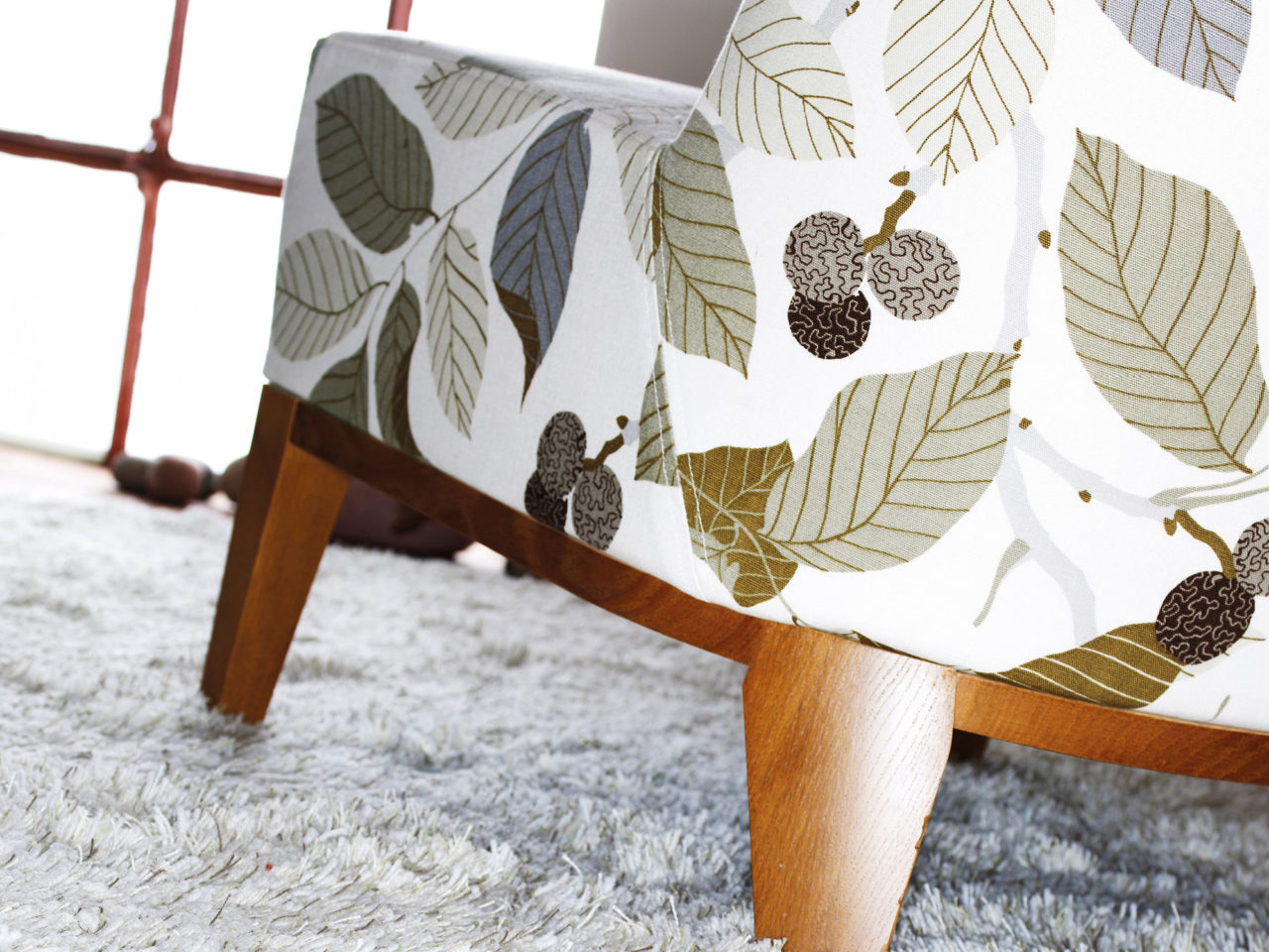 Fåtölj med grön-vitt-svart mönster som föreställer stiliserat fruktträd.