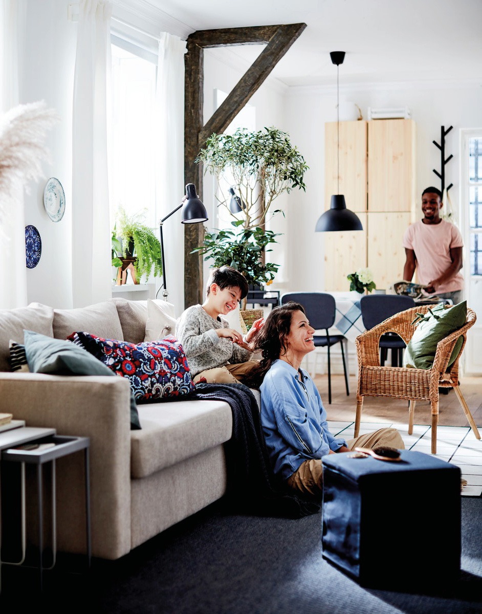 Light and relaxed living room where a young couple and small boy smile and socialise together.