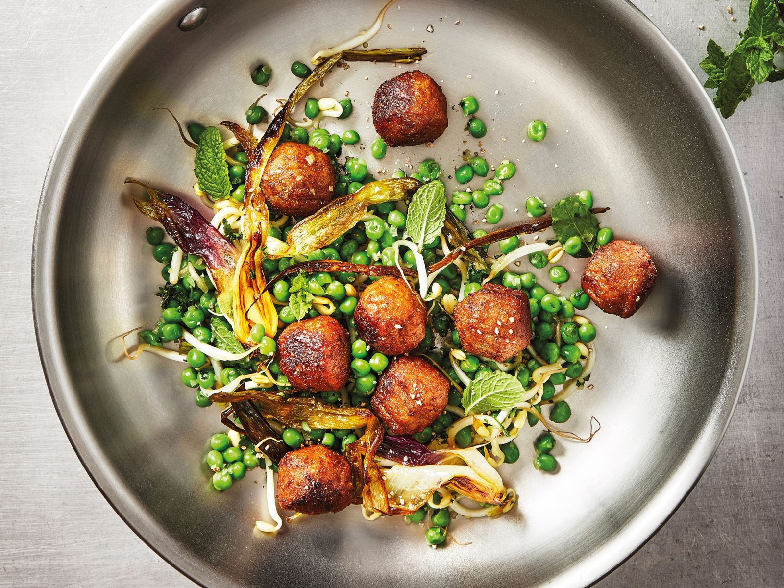 Albóndigas vegetarianas y verduras en la sartén.
