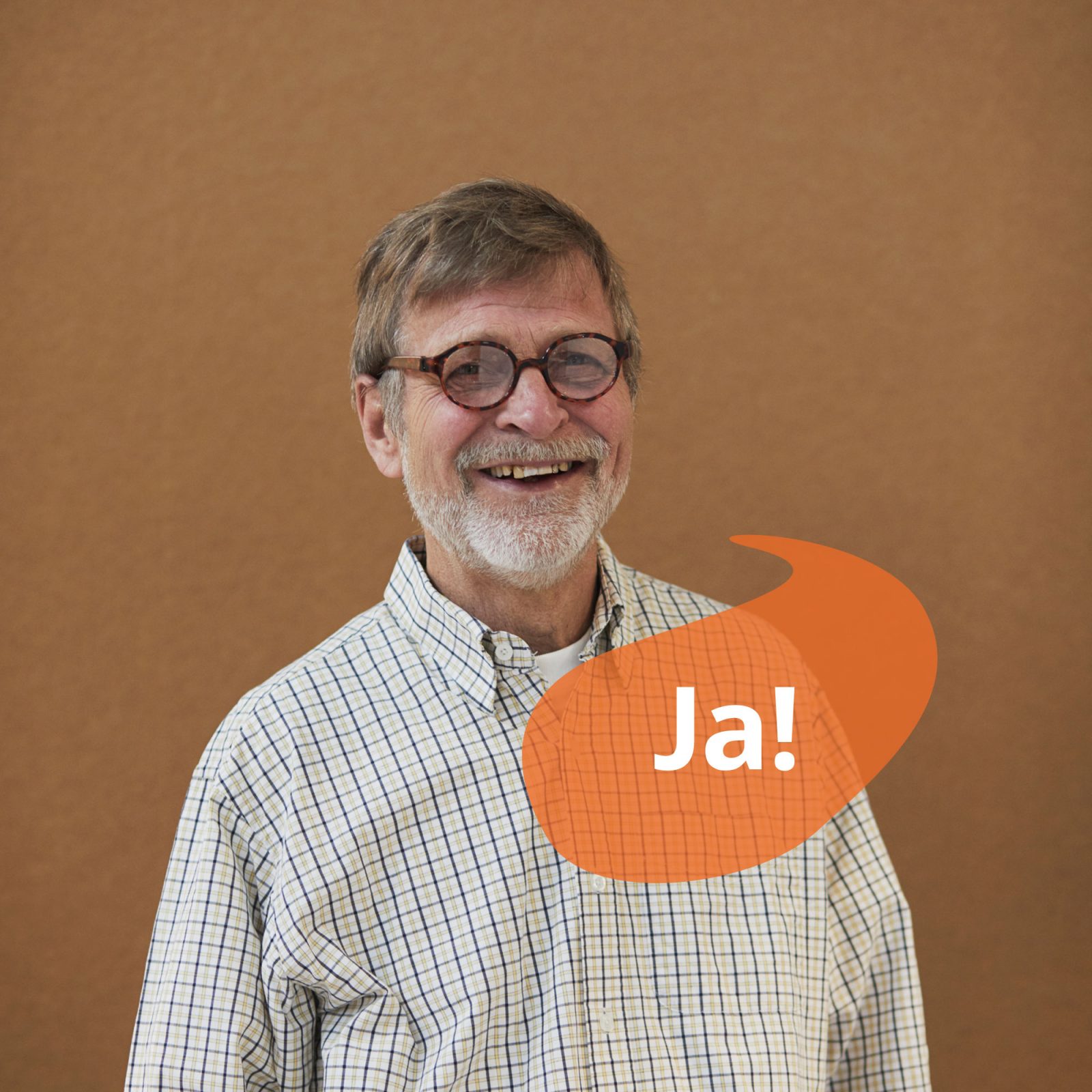 Gråhårig man i glasögon och rutig skjorta ler. En orange pratbubbla har texten 'ja'.