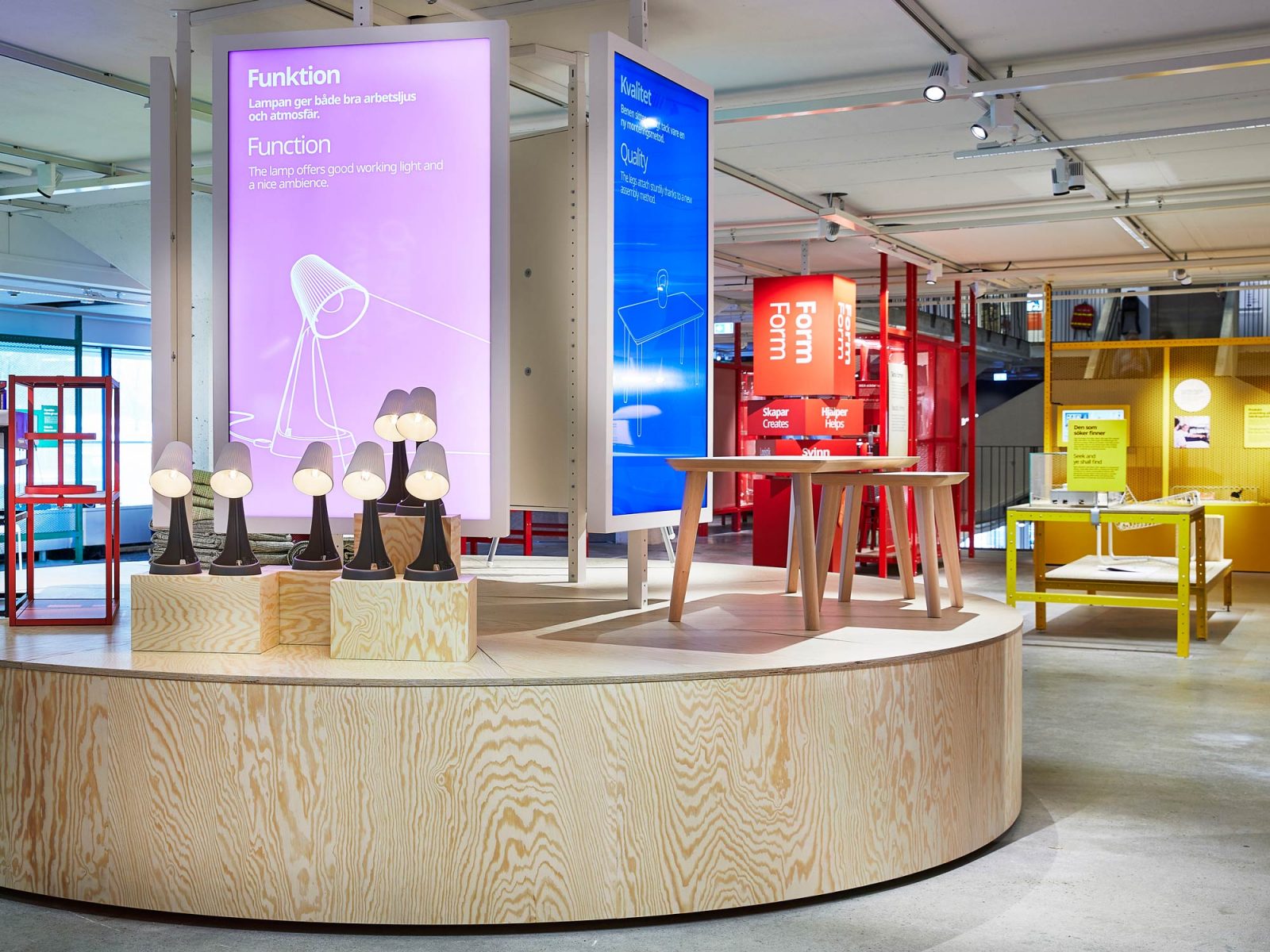 Podium mit Lampen, Tischen und Bildschirmen aus der Ausstellung.