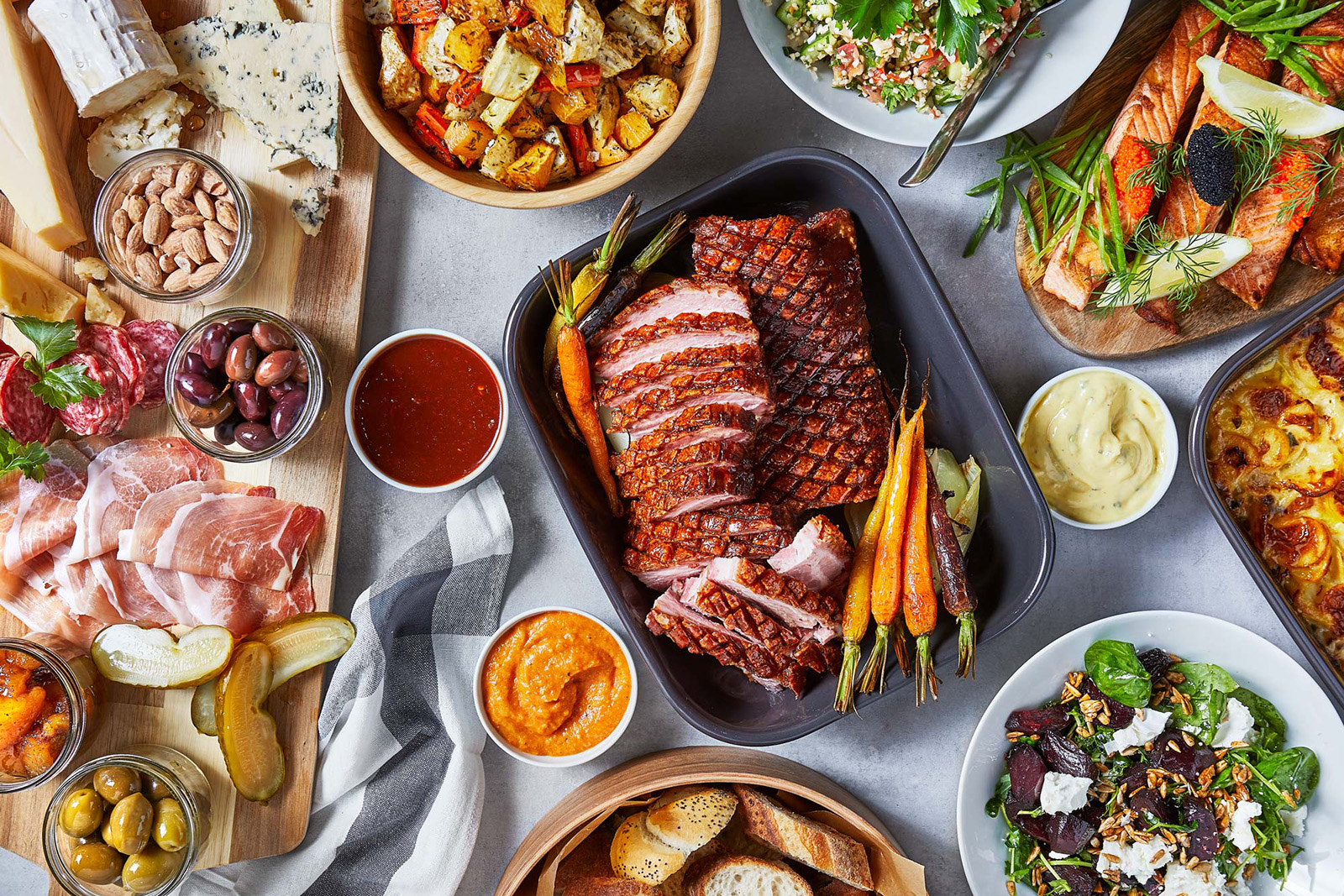 Ein Tisch mit einer weißen Tischdecke voller Essen.