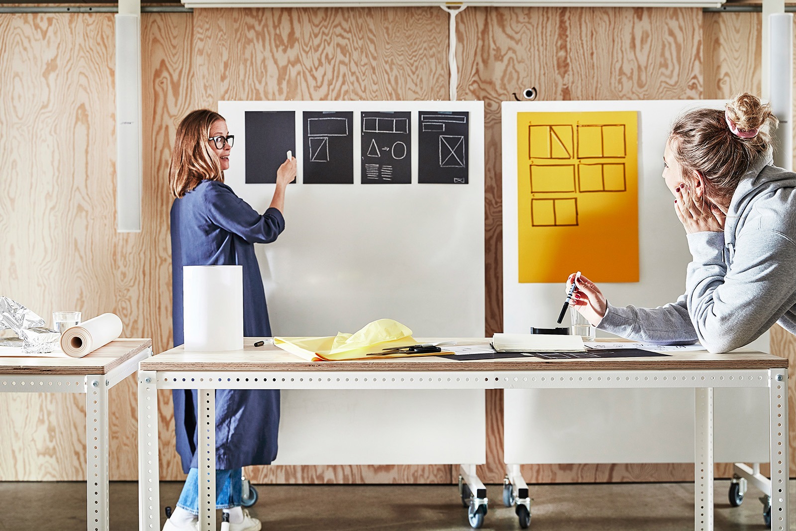 Two people talking, explaining and working on different solutions in a meeting.