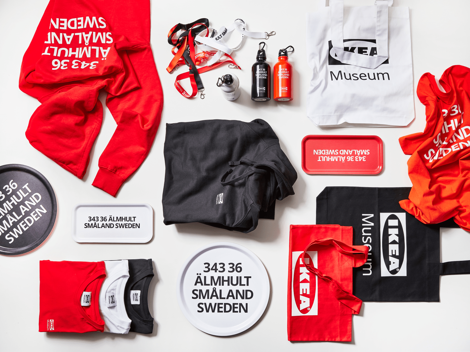 T-Shirts, Hoodies, Tabletts, Thermoskannen und Beutel in Rot, Orange und Schwarz, Aufdruck 343 36, ÄLMHULT SMÅLAND SWEDEN.
