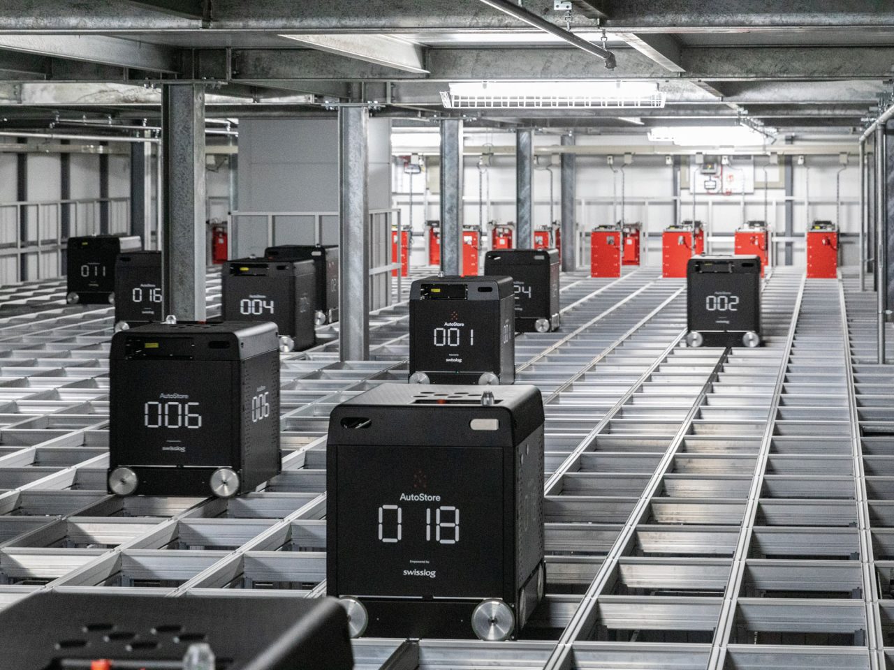 デジタル数字が表示されている車輪付きの黒いボックスが、ハイテク倉庫のトラック上を動き回っている。