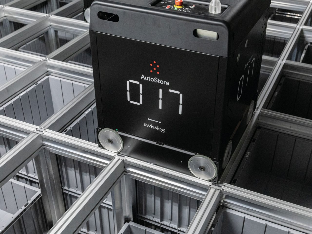 グレーのプラスチックボックス入り、デジタル数字の表示と車輪付きの黒いボックスが金属製のトラック上を動く様子のクローズアップ。