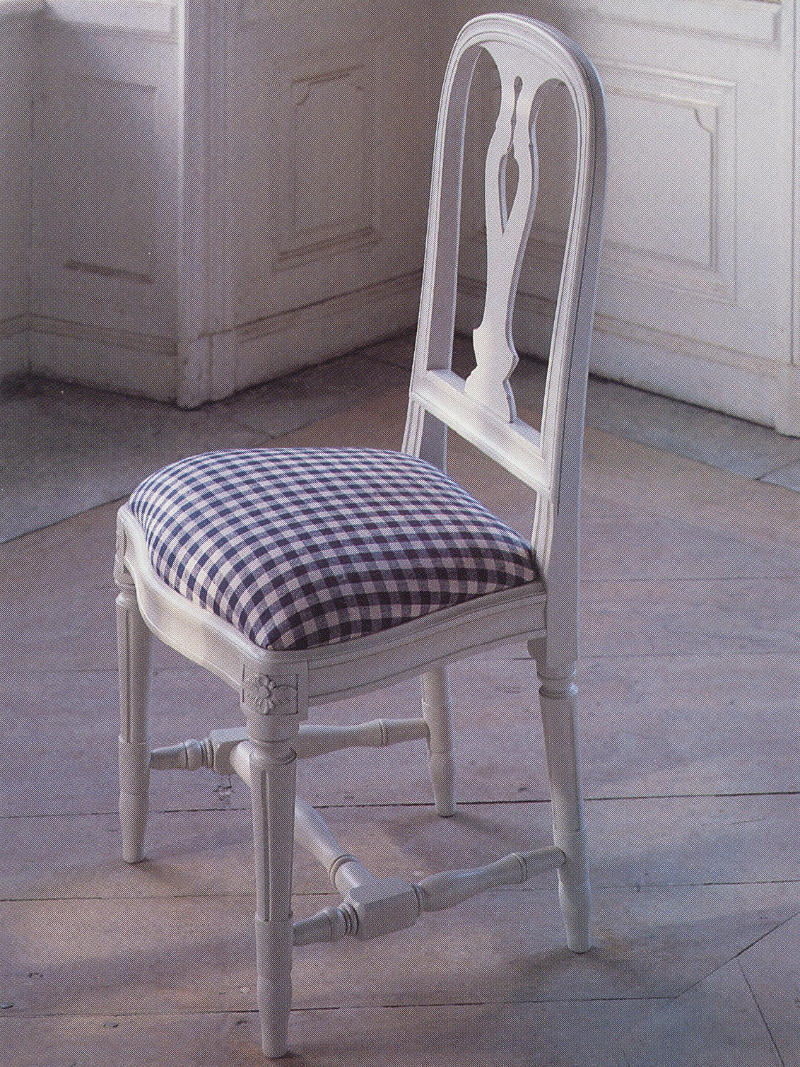 Ljusgrå trästol, HALLUNDA, med stoppad sits i blåvitrutigt tyg.