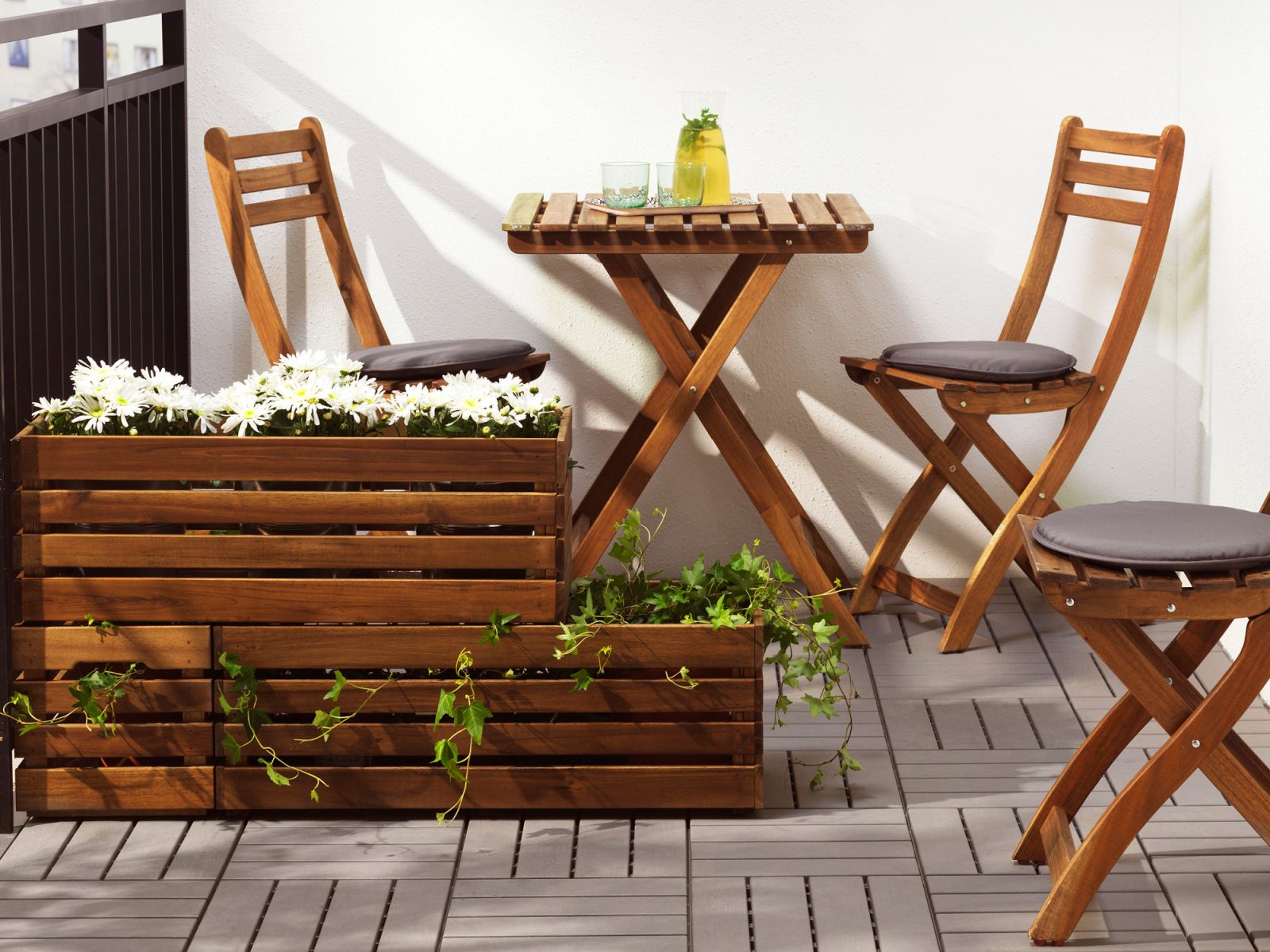 Brown-stained outdoor furniture made of acacia wood on a wooden deck.