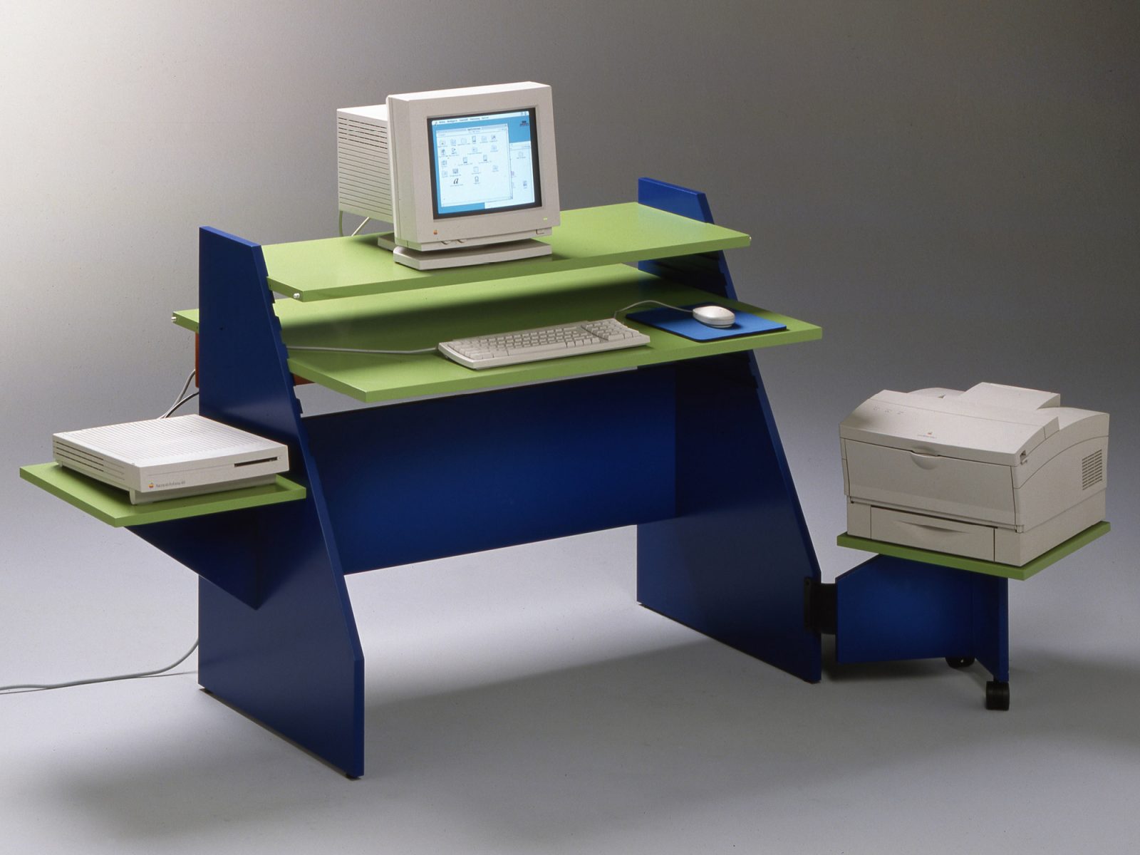 Asymmetrical computer desk CONNY in neon green and black with shelves for keyboard, CD player, and printer.