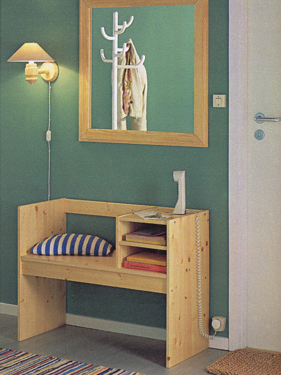 Vit telefon står på hallmöbeln RELING med sittplats med kudde av svart-vitt-randigt tyg.