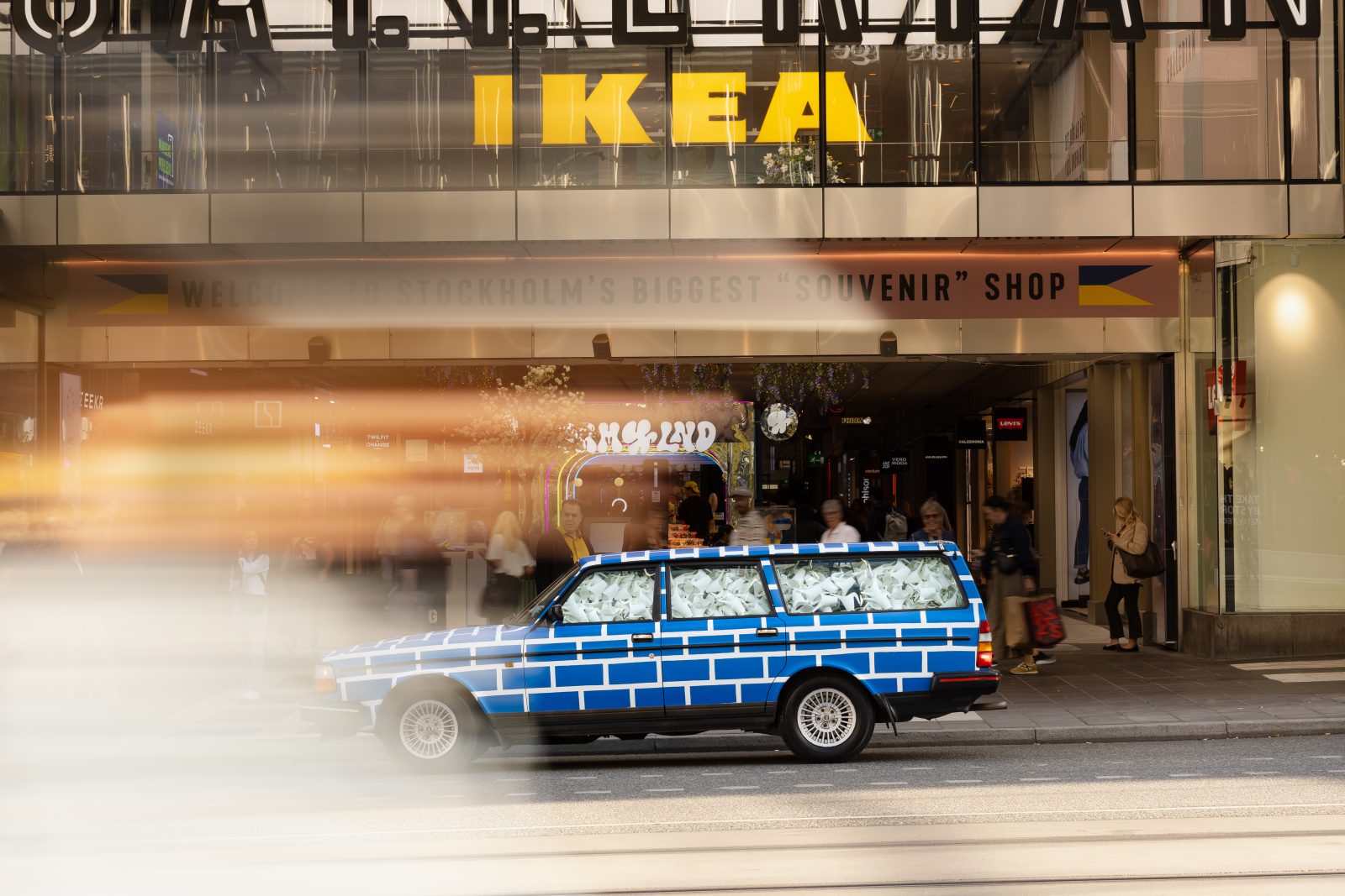Car in front of IKEA department store with white and blue pattern.