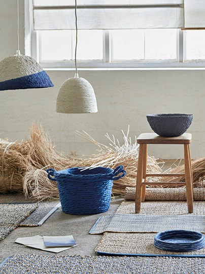 Indigoblå, beige och vitvävda produkter placerade på vävda mattor.