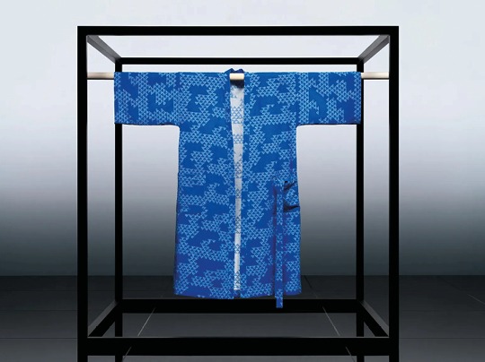 En indigoblå kimono hänger på ställning.