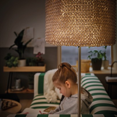 Handstickad lampskärm LERGRYN ger ett varmt, mjukt ljus över en flicka som läser.