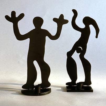 Black metal tealight holders shaped like petroglyphs.