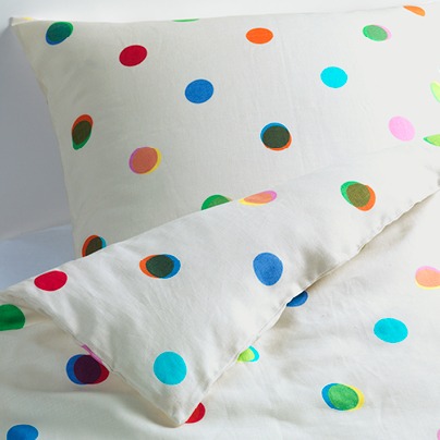 Bed linen decorated with overlapping, colourful spots.