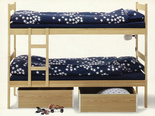 Våningssängar i furu bäddade med mörkblått sänglinne med stjärnor.