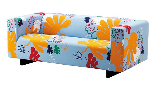 Simple sofa upholstered in bright coloured pattern with leaf motifs.