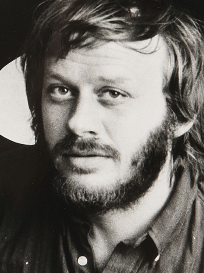 Ung skäggig man med rufsigt hår.