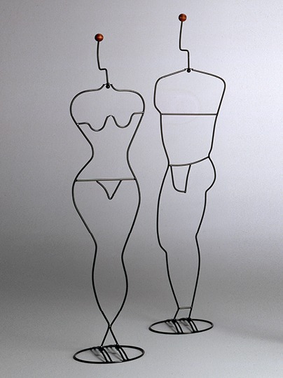 Two metal clothes hangers, one shaped as a naked woman, the other as a naked man.