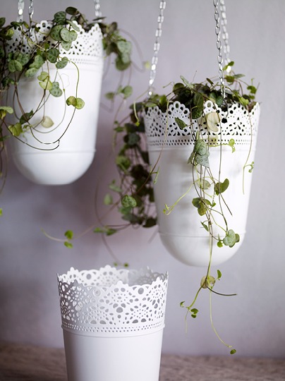 Three white metal plant pots with edges made to look like lace.