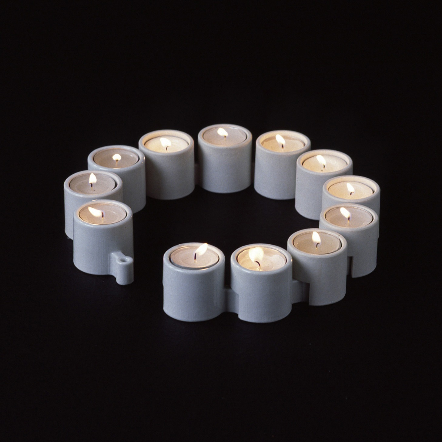 White tealight holders interconnected in a circle.