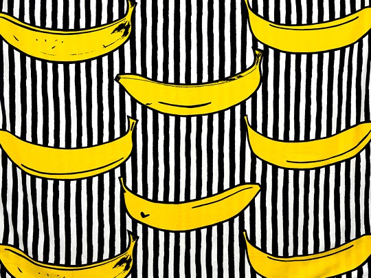 Textilmönstret RANDIG BANAN där gula bananer är tryckta på svartvita ränder.