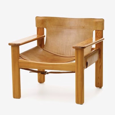 Armchair with leather seating in a wooden frame.
