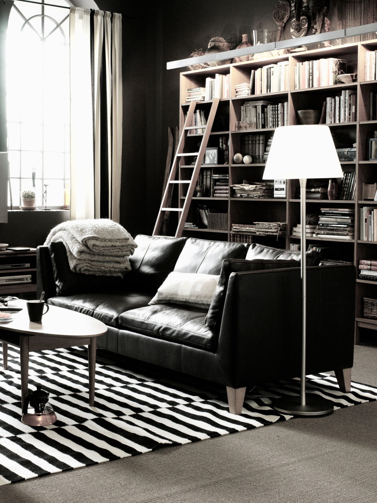 Enkel svart skinnsoffa i stilrent vardagsrum.