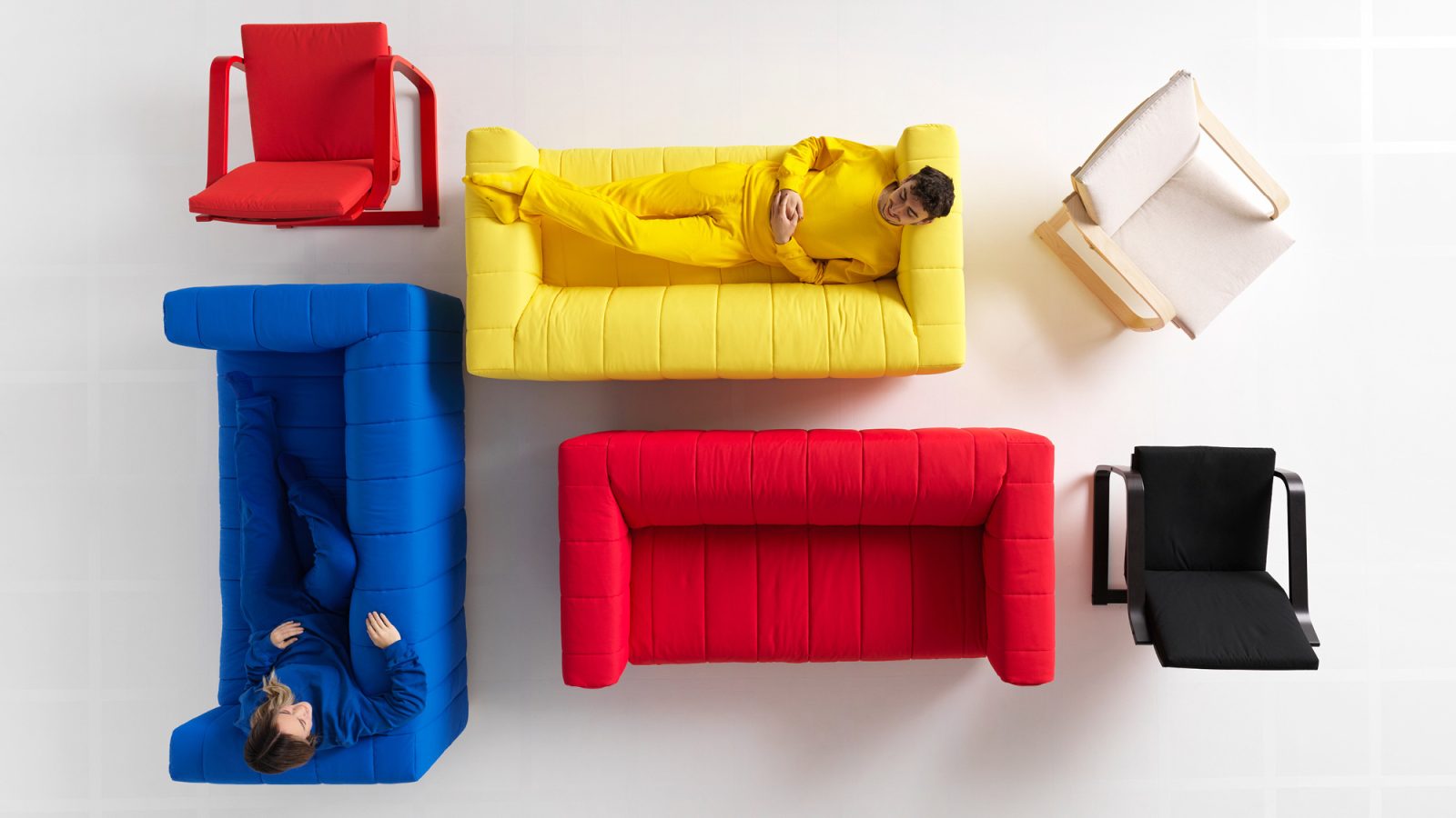 Sofas with puffy covers and simple armchairs, all in bright colours, seen from above.