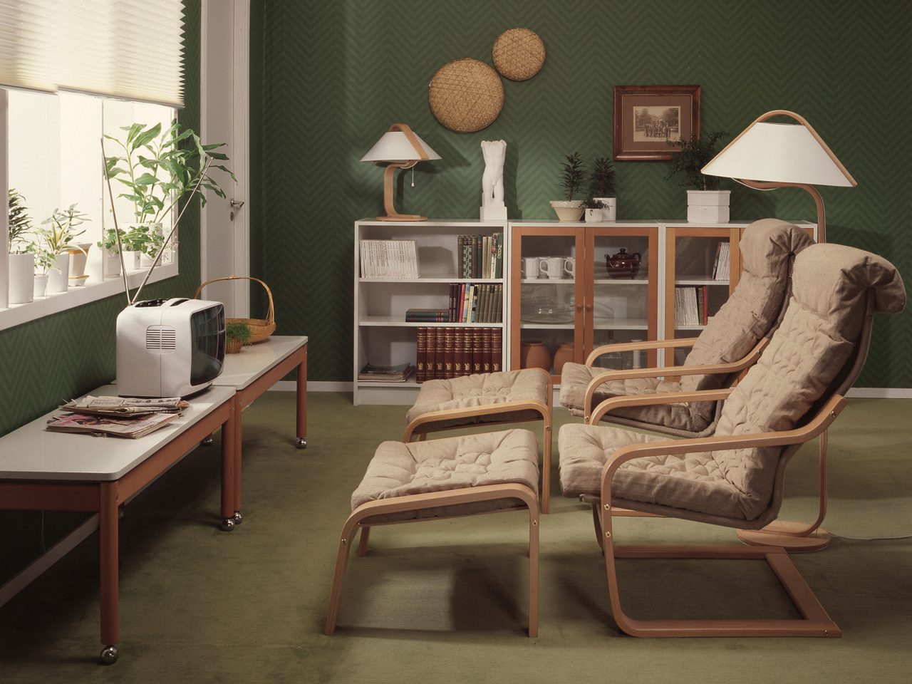 Matching armchairs and footstools with beige cushions and blond wood frames.