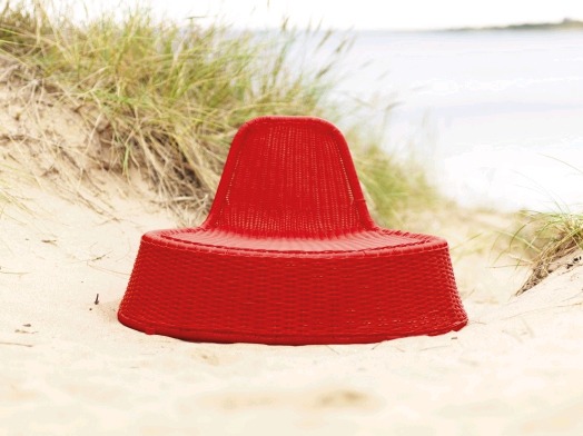 Röd fåtölj står på en sandstrand, VÄNÖ.