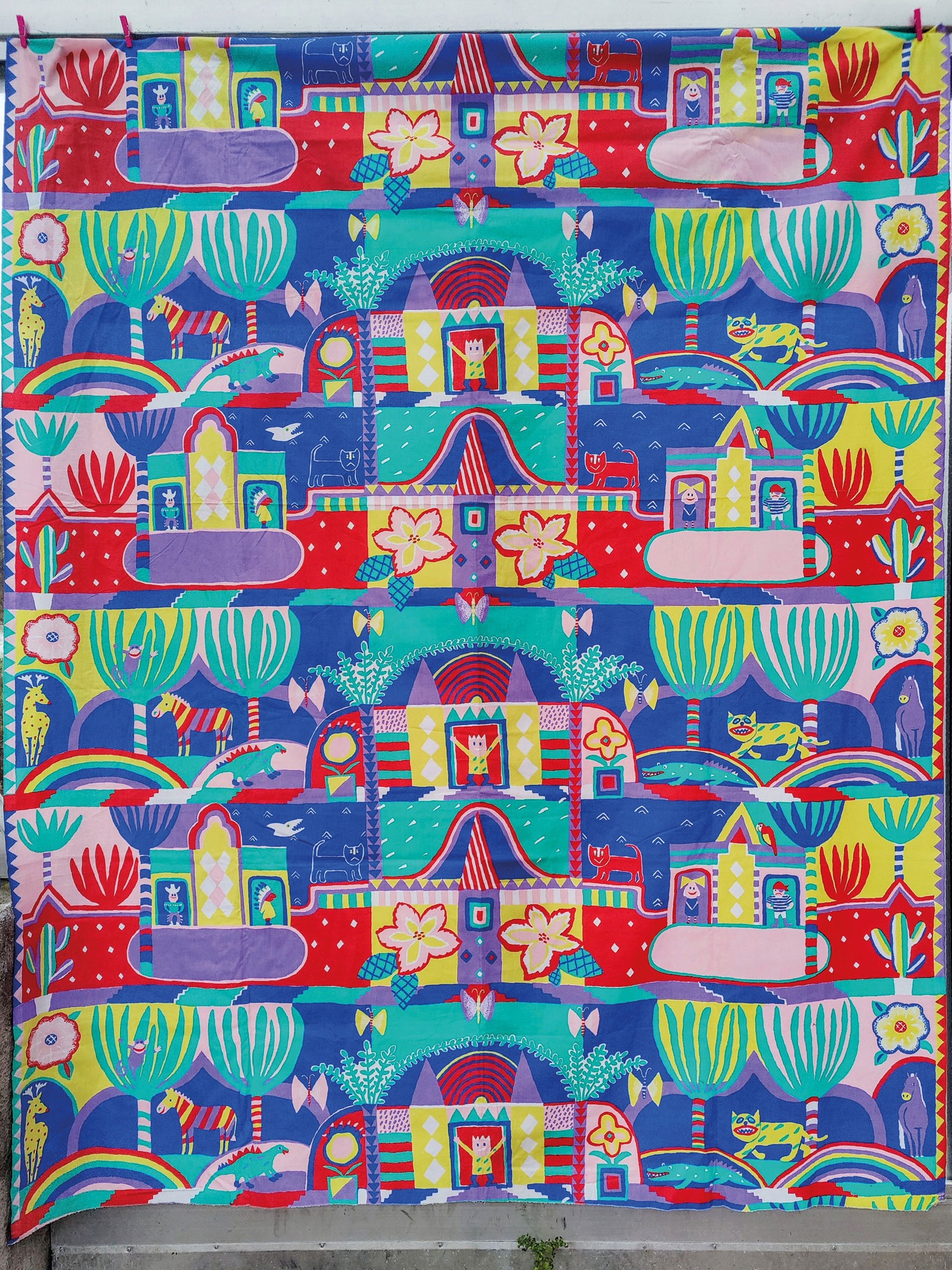 Textile pattern with various characters – people and animals – shown in buildings surrounded by a wild landscape.