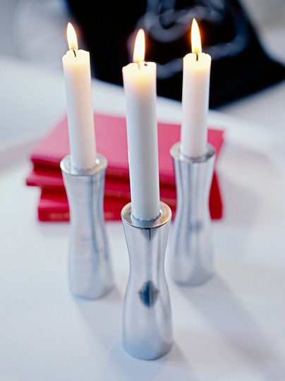 Aluminium silver coloured candlesticks with lit candles, GÖTA.