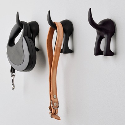 Three black wall hooks shaped like a dog’s tail.