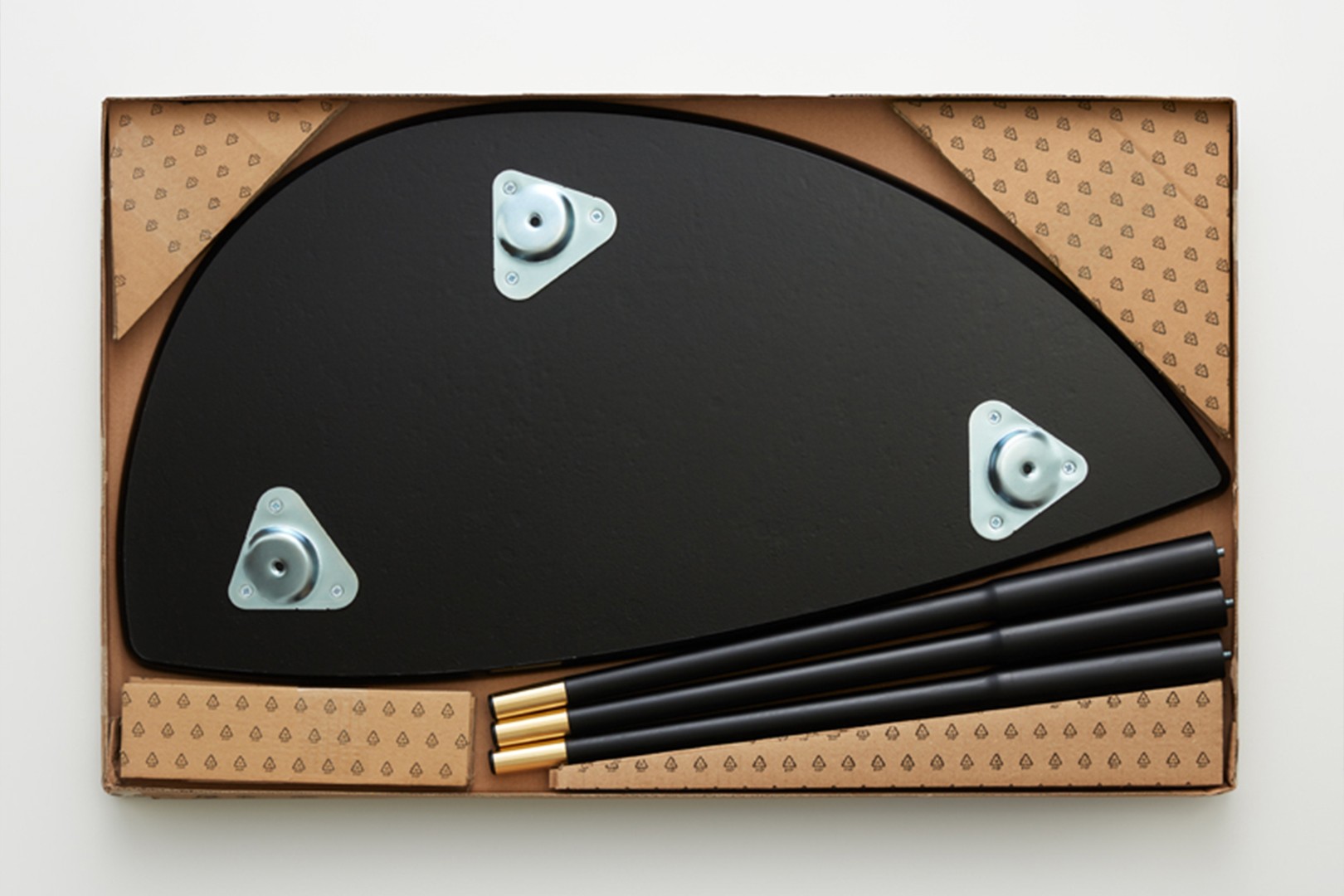 Platt paket med möbeldelar i kartong, inklusive bordsskiva och ben redo för montering