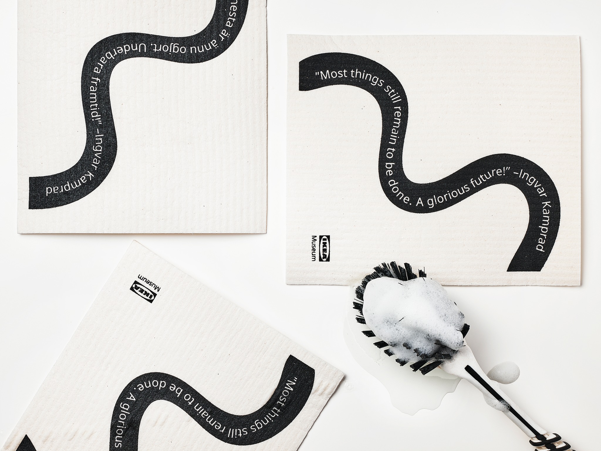 White dishcloths with a black wavy line featuring text.