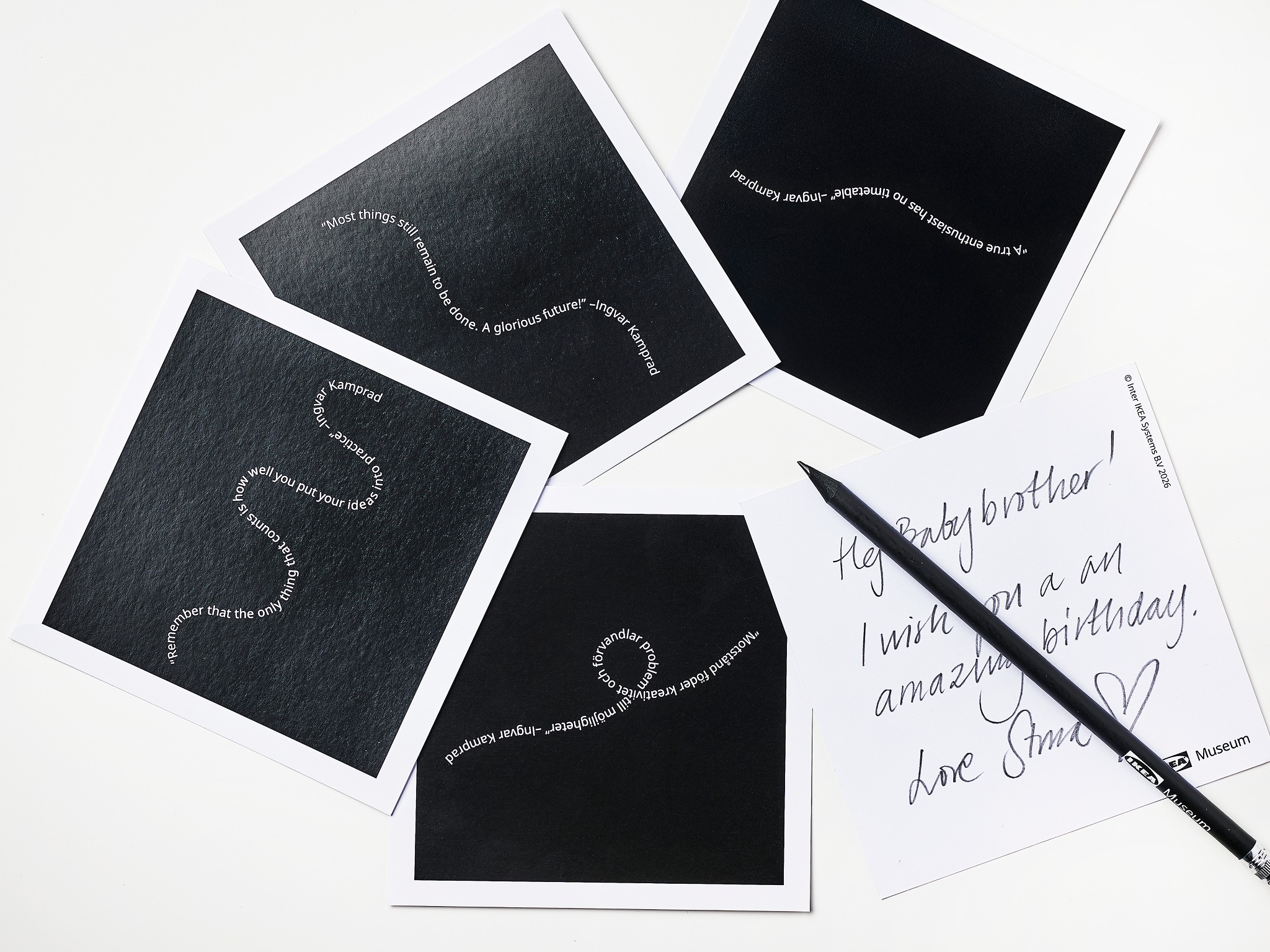 Several black postcards with white wavy text.
