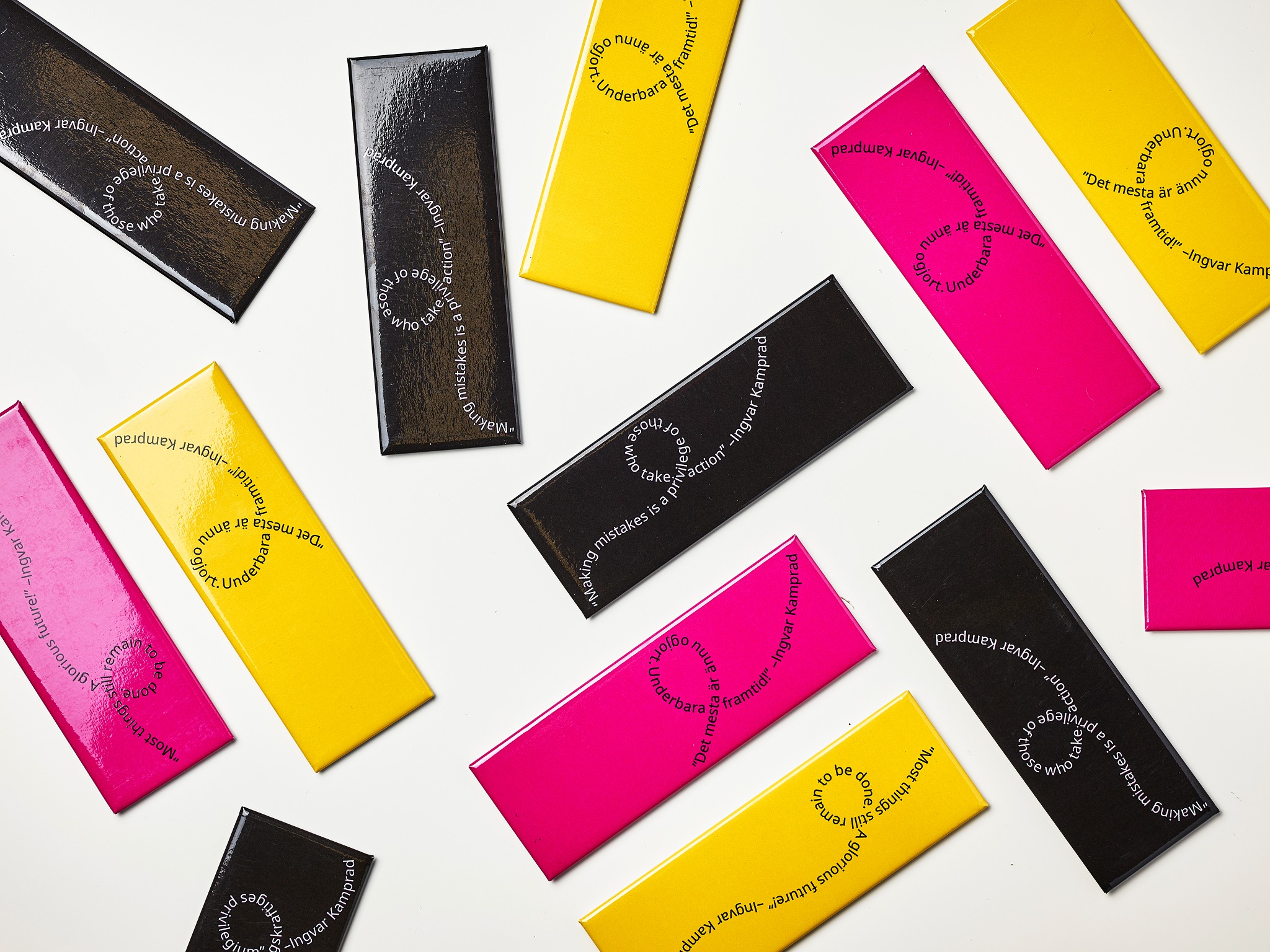 Narrow rectangular magnets in several colors, featuring text.