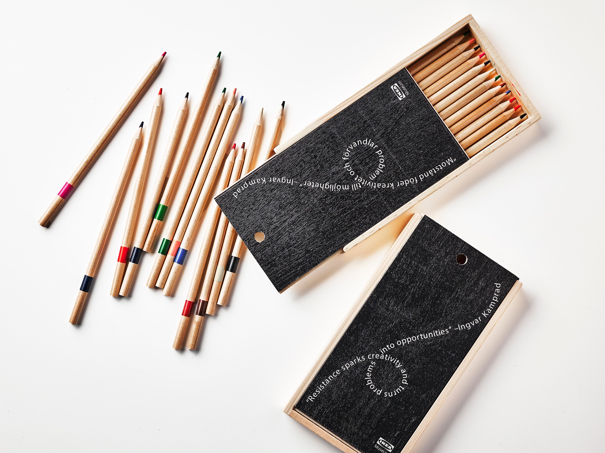Wooden pencil case placed casually with colored pencils scattered around it.