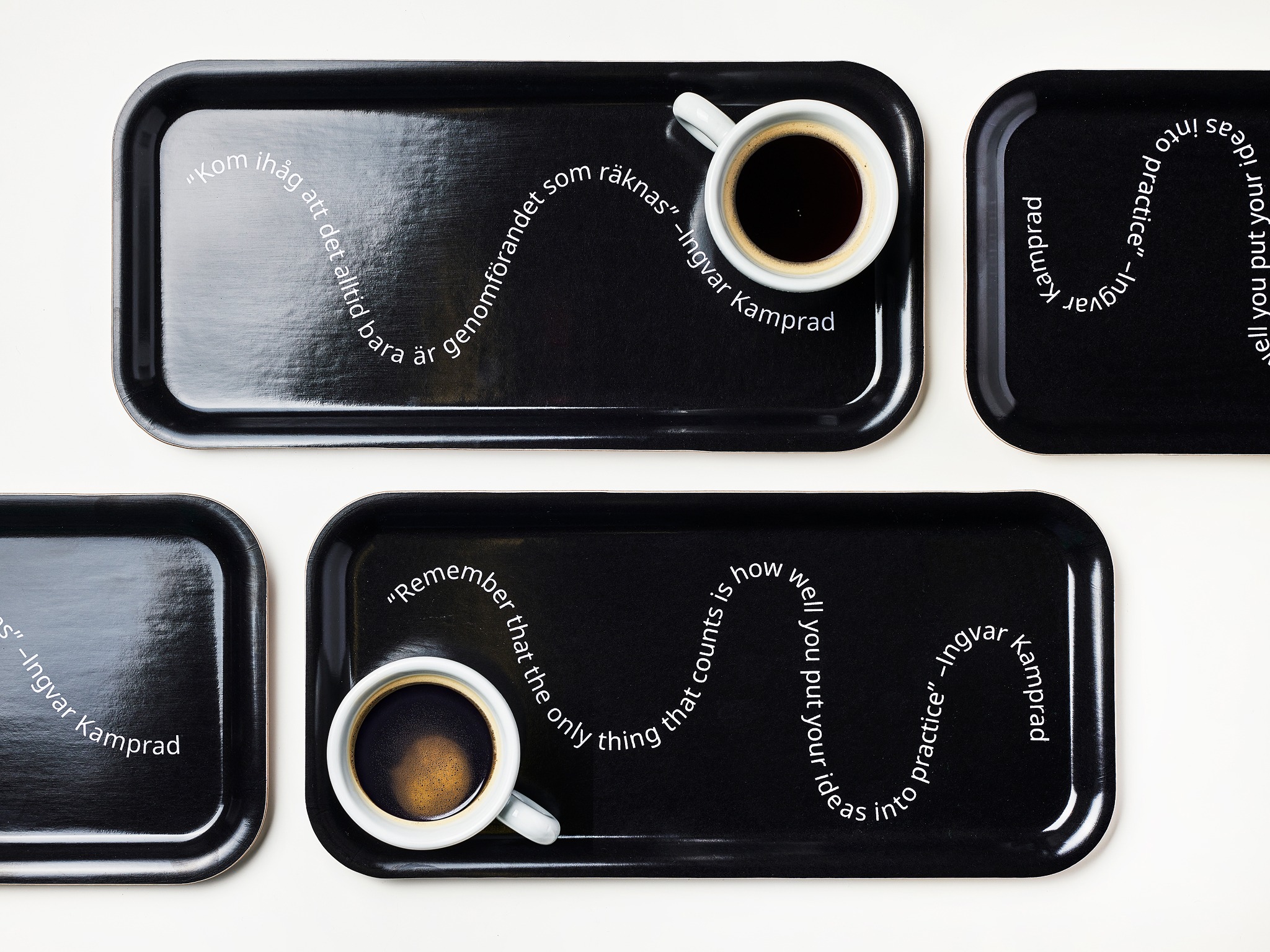 Black, narrow serving trays, carrying coffee cups.